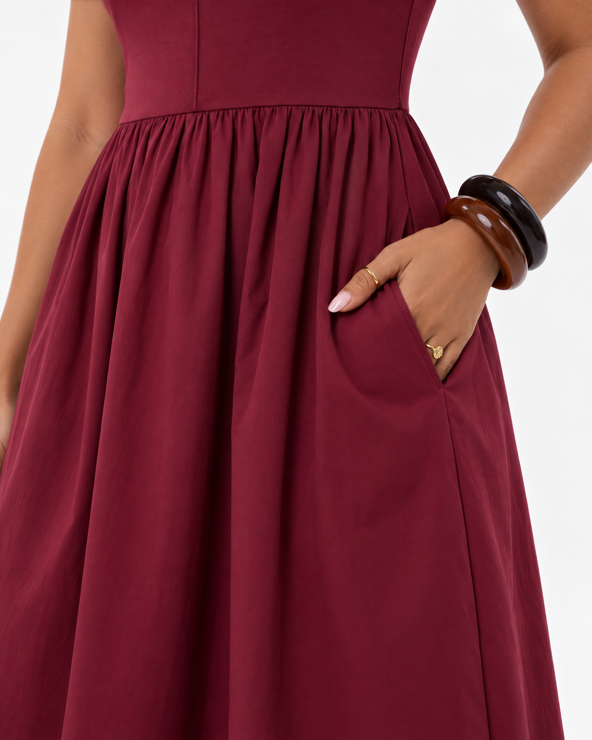 Close-up of the side pocket and gathered waist of THE LAMORAH burgundy midi dress, with the model’s hand inside the pocket.