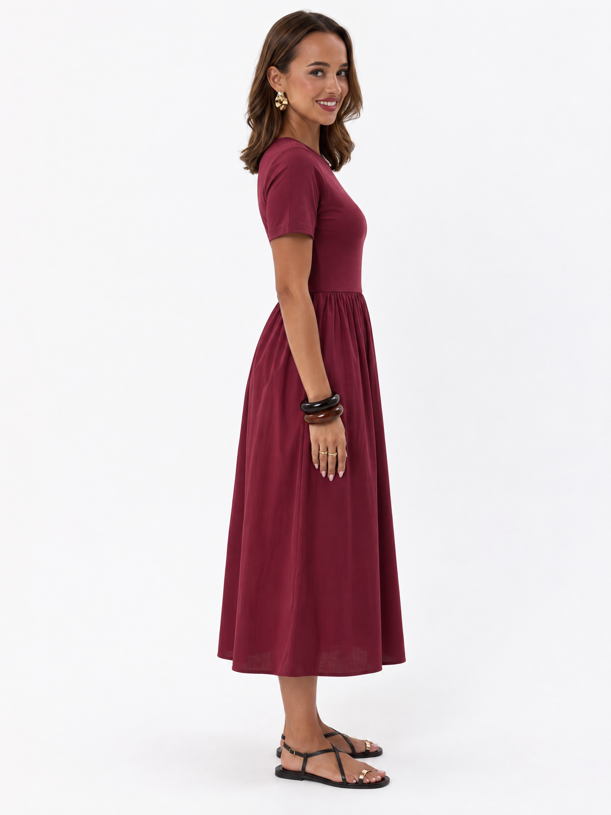 Side view of THE LAMORAH burgundy midi dress, showing the fitted bodice and naturally hanging gathered skirt.