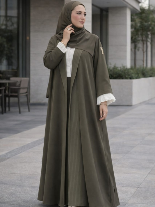 The olive pleated-panel abaya worn with a matching olive shella, from The Lamorah Dubai