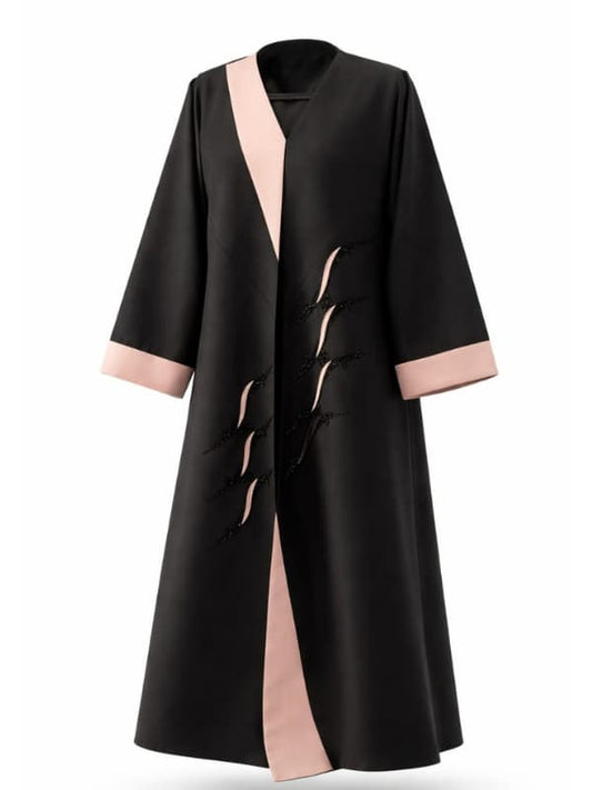 Black abaya with blush pink shawl lapels and cuffs and a diagonal row of black beaded loop motifs, cut to measure by The Lamorah Dubai