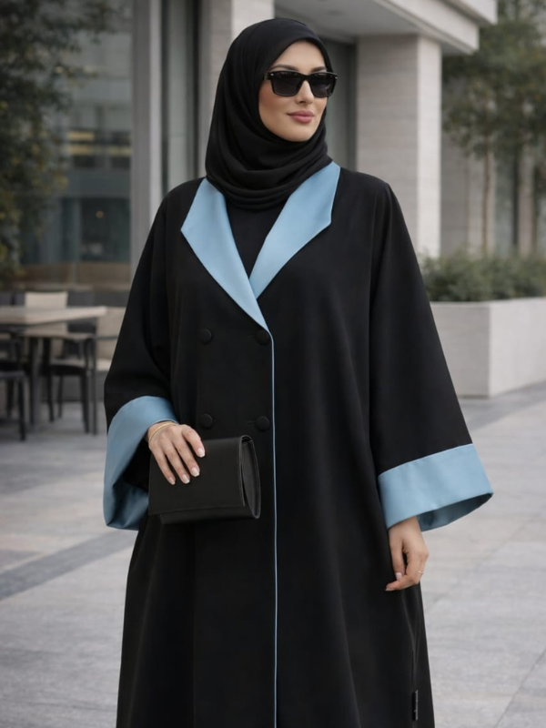 Woman wearing a black abaya with blue trim outdoors.|THE LAMORAH
