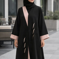 Woman wearing a black abaya with pink accents standing outdoors |THE LAMORAH

