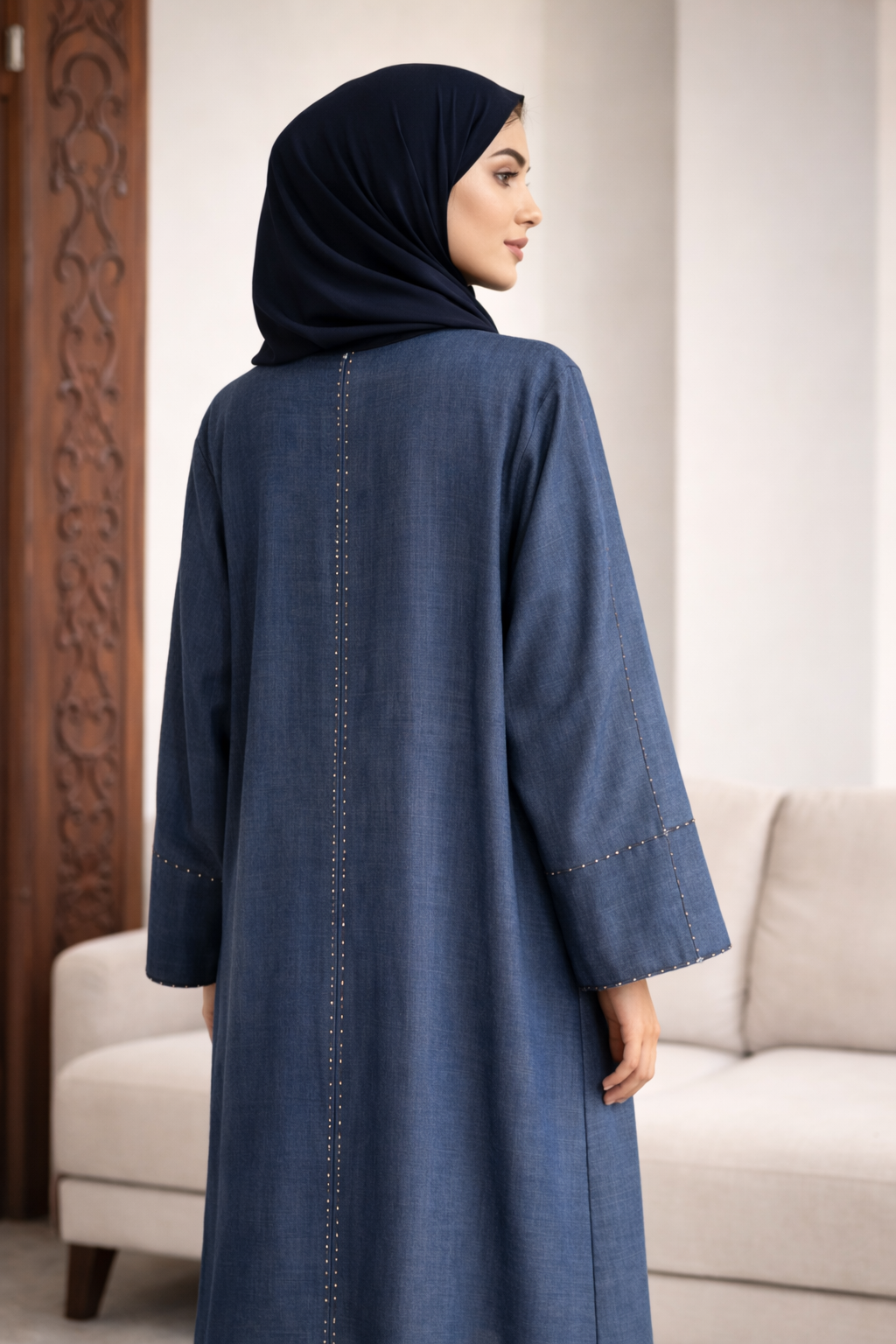 Woman wearing a blue abaya with a hijab in a living room setting | THE LAMORAH