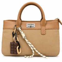 Sand woven canvas mini tote with camel leather trim, silver twist lock and a chocolate bar charm, from The Lamorah Dubai