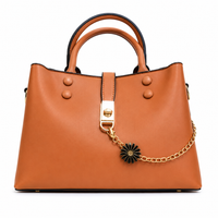 Caramel smooth leather shoulder tote with a gold chain and black daisy charm across the front, from The Lamorah Dubai