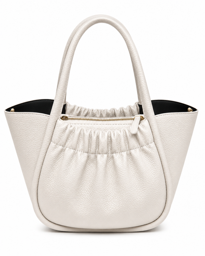 Chalk white pebbled leather bucket tote with a gathered front panel, gold zip and black lining, from The Lamorah Dubai