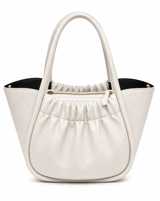 Chalk white pebbled leather bucket tote with a gathered front panel, gold zip and black lining, from The Lamorah Dubai
