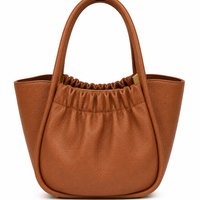 Cognac pebbled leather bucket tote with a gathered front panel and winged top, from The Lamorah Dubai