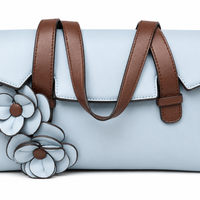 Powder blue flap bag with chestnut brown strap handles and two applied leather flowers on the front, from The Lamorah Dubai