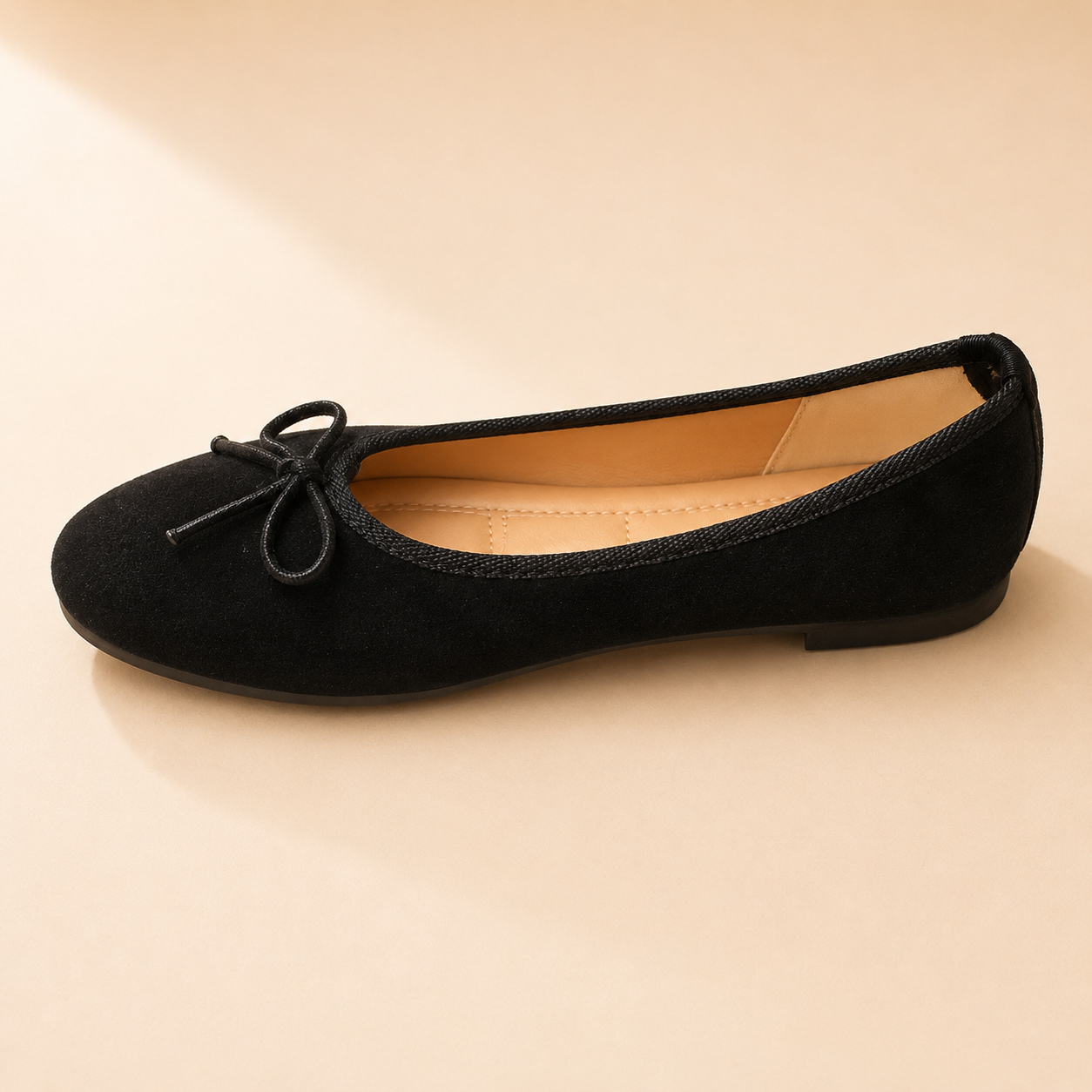 Black suede ballet flat with a slim black bow and a bound edge, from The Lamorah Dubai