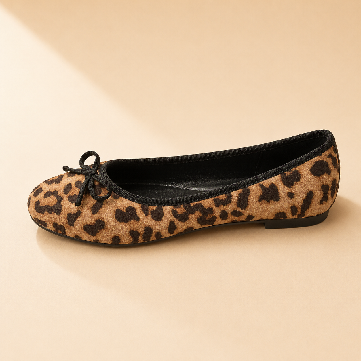 Leopard print ballet flat with a black bow and black bound edge, from The Lamorah Dubai