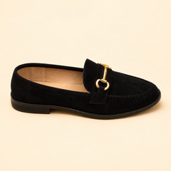 Black suede loafer with a stitched moccasin toe and a slim gold bar across the strap, from The Lamorah Dubai